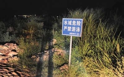 岸边竖有四面警示牌