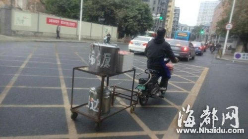 男子骑电动车拖铁锅满街跑　装满滚烫食物被罚20
