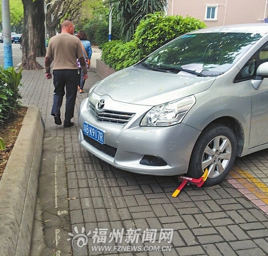 小车停数天车主未露面　看车人怕“逃单”锁车轮