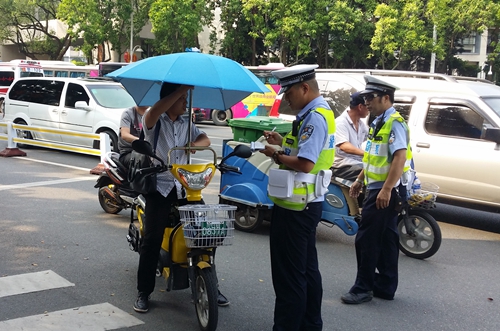 福州华林路，装遮阳伞的一辆电动车被警察拦下