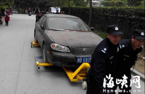 “僵尸车”长期占车位堵路　物业强拖业主点赞　