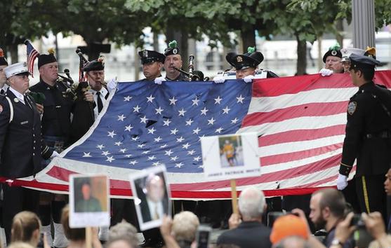 9月11日，在美国纽约，礼兵在“9·11”恐怖袭击事件纪念活动上展示15年前的一面美国国旗。