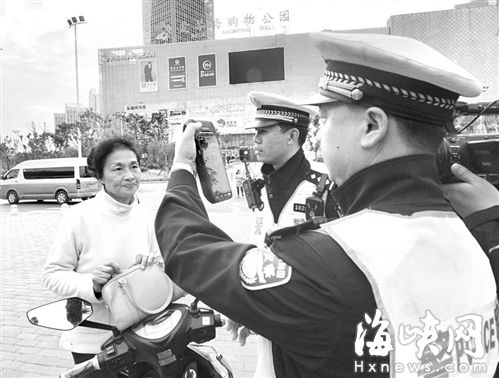 交警对闯红灯的电动车骑手进行人脸识别